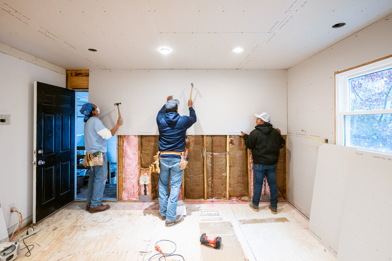 Restoration professional cleaning soot from fire-damaged wall