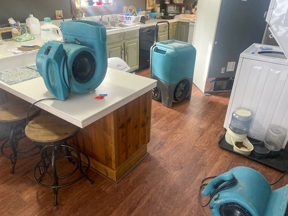 Professional drying equipment running in a water-damaged room