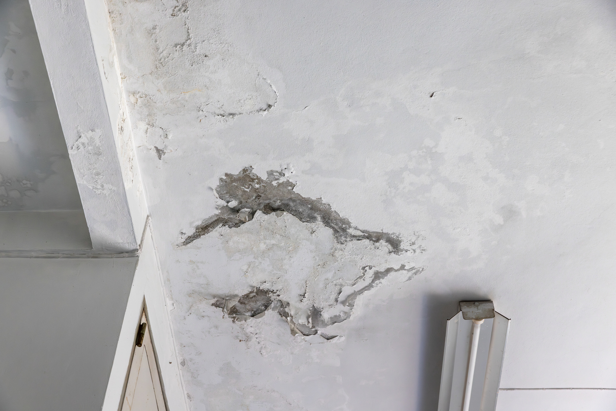 Water damaged ceiling with sagging drywall and stain